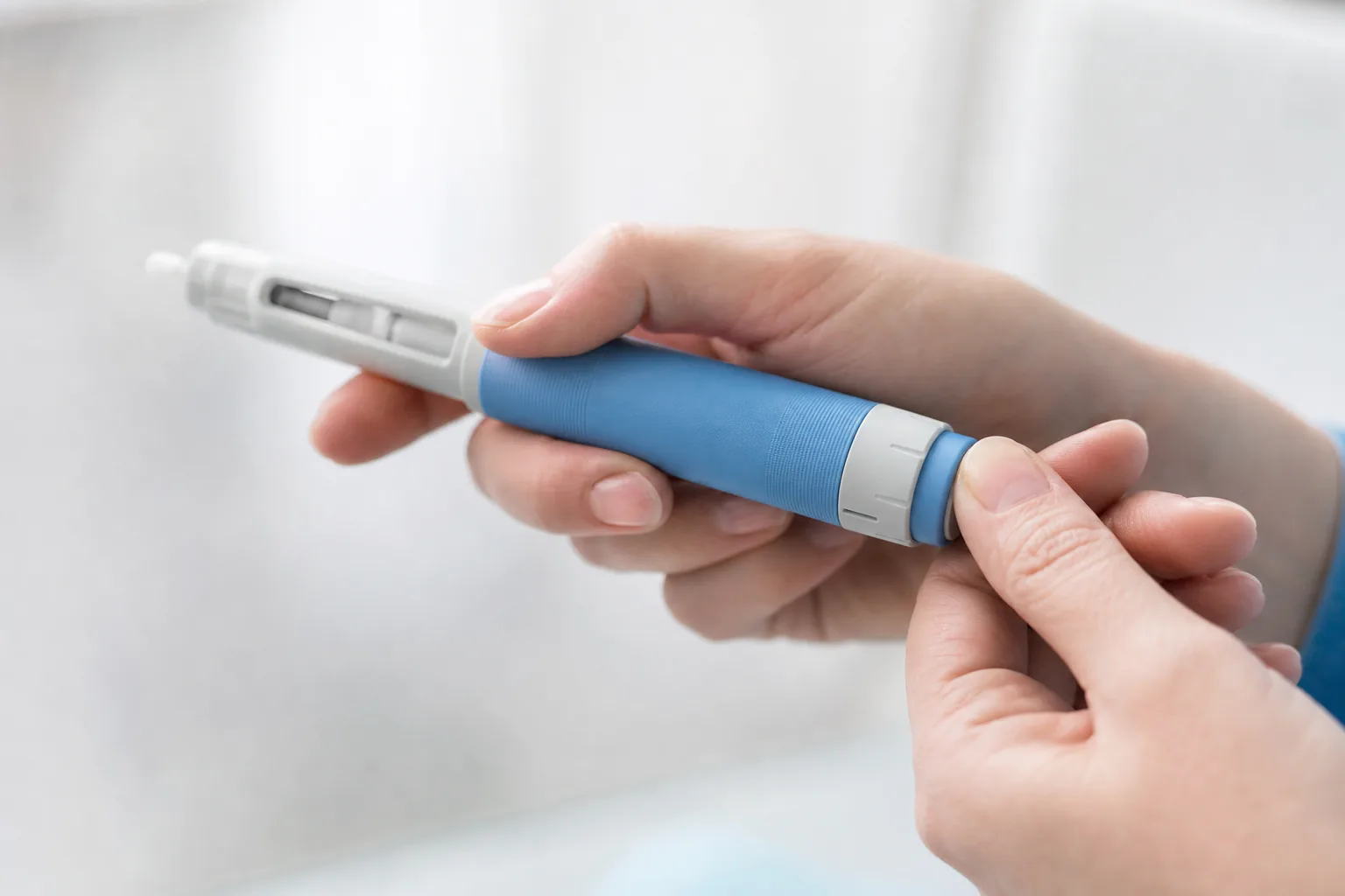 Hand stellt an einem Injektions-Pen mit Dosis-Wählrad die Dosis ein